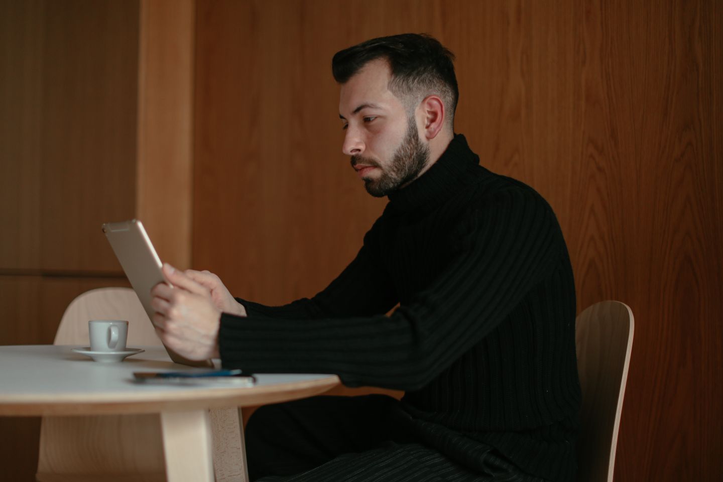 Návštevník prezerá obsah na tablete pri stole v kaviarni